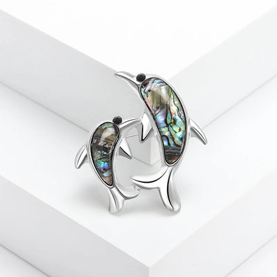 The Tropicana Nai'a Dolphin Brooch - A beautiful silver-toned zinc alloy dolphin brooch adorned with crystals and polished paua shell.