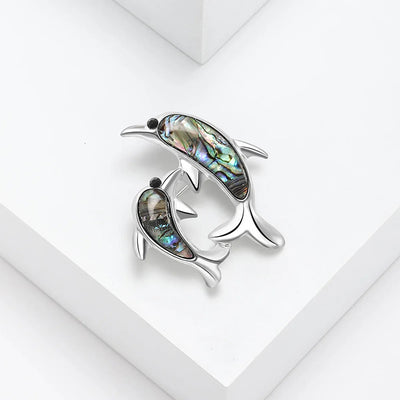 The Tropicana Nai'a Dolphin Brooch - A beautiful silver-toned zinc alloy dolphin brooch adorned with crystals and polished paua shell.