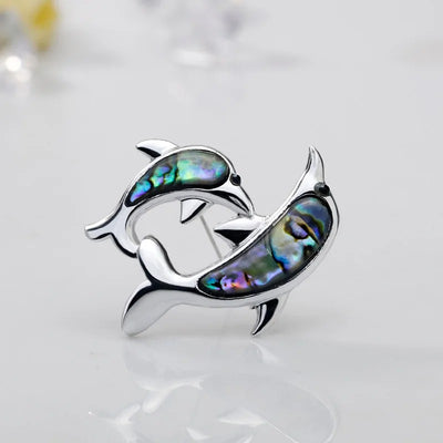 The Tropicana Nai'a Dolphin Brooch - A beautiful silver-toned zinc alloy dolphin brooch adorned with crystals and polished paua shell.