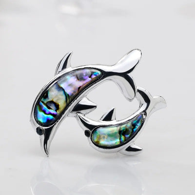 The Tropicana Nai'a Dolphin Brooch - A beautiful silver-toned zinc alloy dolphin brooch adorned with crystals and polished paua shell.