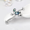 The Tropicana Poloka Frog Brooch - A beautiful silver-toned zinc alloy frog brooch adorned with crystals and polished paua shell.