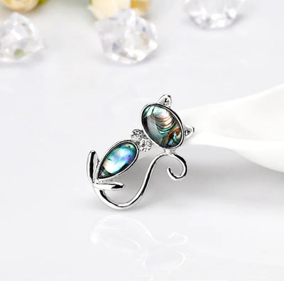 The Tropicana Popoki Cat Brooch - A stylised silver-toned zinc alloy cat brooch adorned with polished paua shell and artificial crystals.
