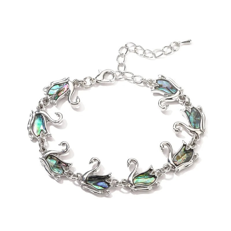 The Tropicana Ululani Swan Bracelet - A beautiful silver swan bracelet adorned with lovely polished paua shell.