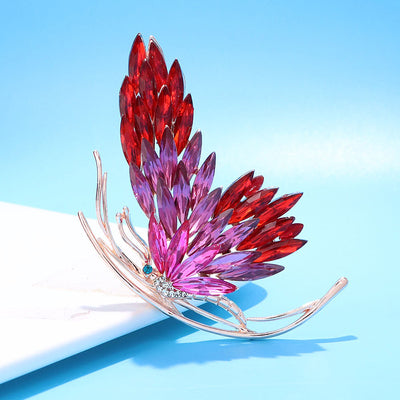 Tulia Oversized Butterfly Brooch - A huge crystal brooch featuring a side-view of a butterfly with a gradient of crystals making up its wings, available in green, reddish pink, or yellow colour palettes.