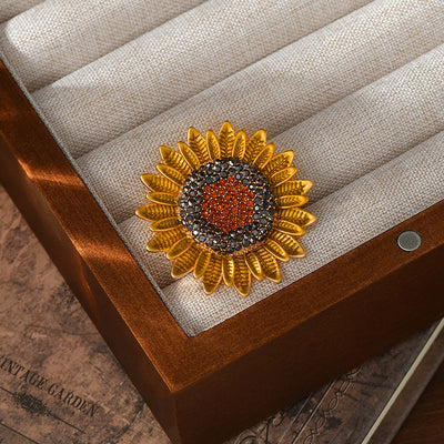 The Elidi Sunflower Brooch. This beautiful brooch is a simple, but elegant classical stylised sunflower, with glossy yellow petals, and sparkling crystals around the inside of the blossom.