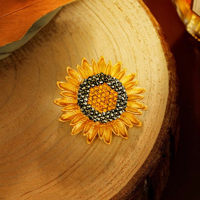 The Elidi Sunflower Brooch. This beautiful brooch is a simple, but elegant classical stylised sunflower, with glossy yellow petals, and sparkling crystals around the inside of the blossom.