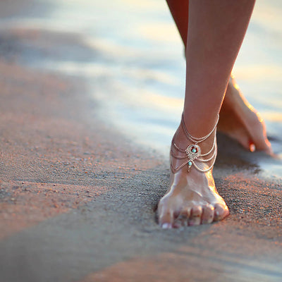 Delilah Bohemian Strand Anklet - A complex multi-strand dark silver anklet with lots of chains clustered around a central pendant, and a handful of turquoise beads.