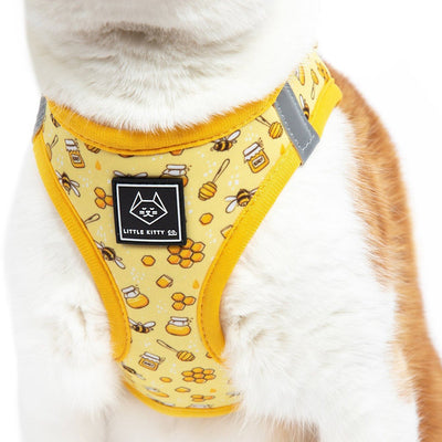 Little Kitty Co. Cat Step-In Harness - Bee-Hiving is a vibrant yellow harness featuring an adorable little print of cartoon bumblebees and honey. Buzz buzz, baby!