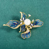 The Lorelei Lily Sculpted Resin Brooch - A lovely, long, elegant piece that features a five-petal lily clustered around a single pearl, with colourful resin to really make it pop and a dusting of crystal along the underside of the petals.