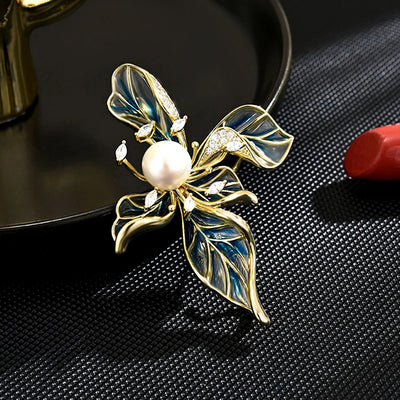 The Lorelei Lily Sculpted Resin Brooch - A lovely, long, elegant piece that features a five-petal lily clustered around a single pearl, with colourful resin to really make it pop and a dusting of crystal along the underside of the petals.