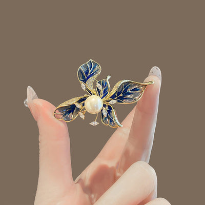 The Lorelei Lily Sculpted Resin Brooch - A lovely, long, elegant piece that features a five-petal lily clustered around a single pearl, with colourful resin to really make it pop and a dusting of crystal along the underside of the petals.