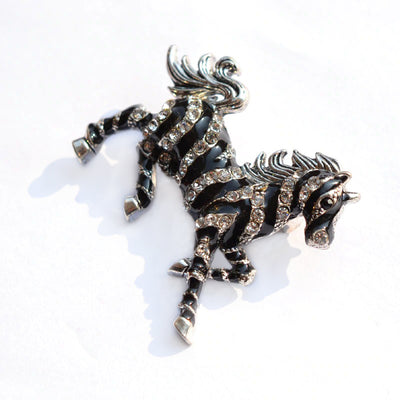 Zesty Zebra Brooch - A medium sized brooch shaped like a zebra running with its mane and tail flowing in the wind. It's available in gold or silver colours, and is studded with crystals.
