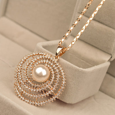 The Galaxy In Abstract Necklace - A long gold and crystal necklace with an elegant spiral motif.