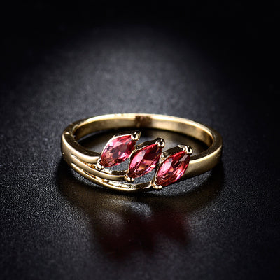 The Modern Classic - A simple gold band studded with three vibrant red stones.
