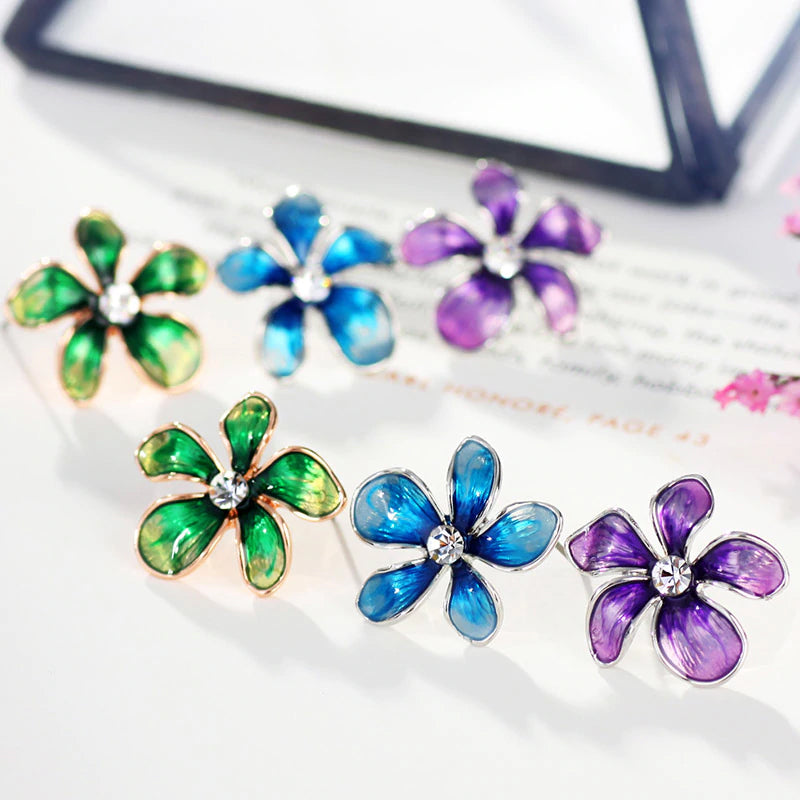 Asymmetrical flower earrings available in bright shades of blue, green, and purple. 