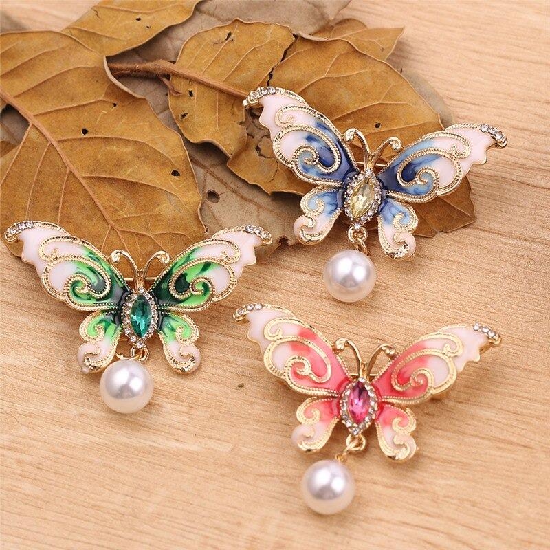 A lovely butterfly brooch with rhinestone crystal and pearls available in blue, green, and pink.
