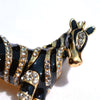 Zealous Zebra Brooch - A medium sized brooch shaped like a zebra standing still and looking forward, with a gold and black enamel background and studded with small crystals.