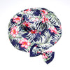 Caribbean Cruise Reversible Sunhat - A large-brimmed, floppy sunhat with a solid colour on one side and a vibrant floral print on the other, which can be worn either way depending on the user's choice. It is decorated with a large removable bow. This image shows the Navy colour on a flat white background, which is a very dark blue. The floral print also has a dark blue background.