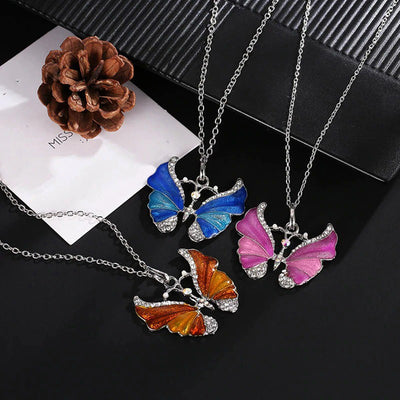 The Adonis Butterfly Necklace - Beautiful medium length silver coloured necklaces with butterfly pendants in blue, green, red, pink, purple, and honey orange gold.