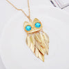 Athena Sweater Chain - A long golden chain with a stylised owl-themed pendant strung on it.