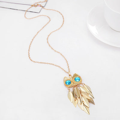 Athena Sweater Chain - A long golden chain with a stylised owl-themed pendant strung on it.