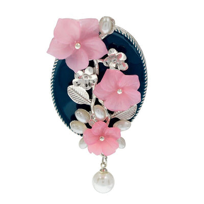 Ayana Cherry Blossom Brooch - An oval shaped blue brooch with silver coloured branches and pink flowers.
