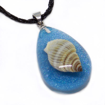 Calypso's Tear Necklace - A teardrop-shaped resin necklace featuring a tiny little seashell trapped in coloured amber, strung on a surfer-style leatherette necklace.