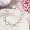 Colette Cut-Out Heart Choker - A close-fitting choker style necklace featuring a series of interlinked hollow heart charms.