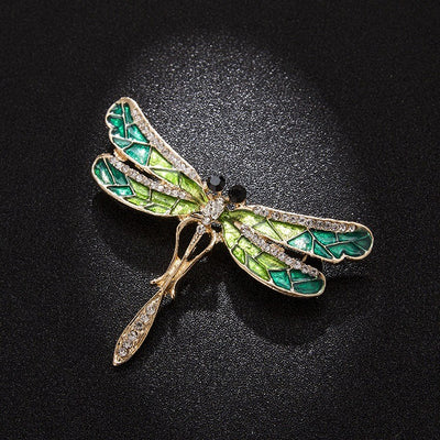 Estelle Dragonfly Brooch - A large green and gold dragonfly-themed brooch with metallic enamel paint on the wings and an assortment of shimmering crystals.