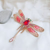Etain Oversized Dragonfly Brooch - An extremely large brooch shaped like a stylised dragonfly, with a large coloured crystal on its back and translucent, colourful wings.
