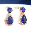 Imogen Luxury Crystal Dangle Earrings - Vintage-style earrings with a teardrop-shaped dark blue stone surrounded by little white stones, and a round stone on the lobe.