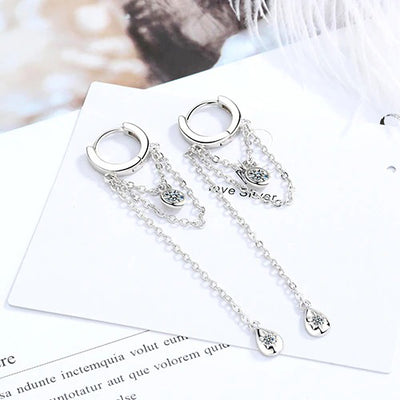 Lucyna Tassel Chain Lever Back Earrings - Small, delicate silver huggies with three chains suspended from them, two of which have little charms attached.