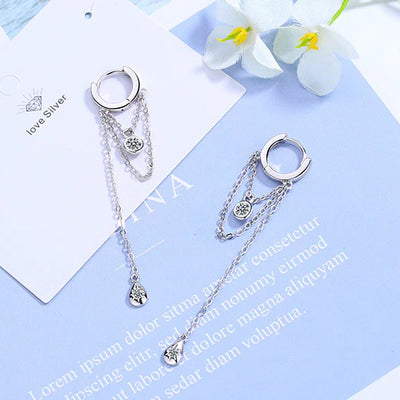 Lucyna Tassel Chain Lever Back Earrings - Small, delicate silver huggies with three chains suspended from them, two of which have little charms attached.