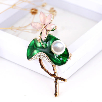Mika Enamel Lotus Brooch - A lovely colourful brooch with a green metallic lily pad, a flower constructed of marquise cut pink crystals, and delicate pave-style crystals along the underside of the leaf.