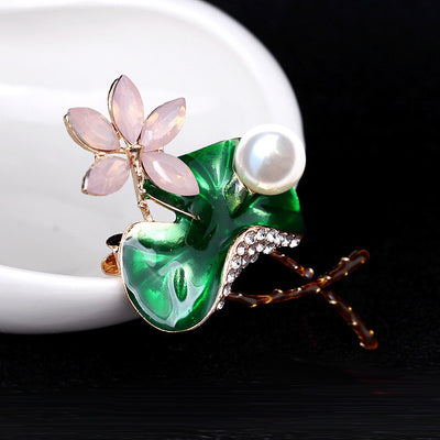 Mika Enamel Lotus Brooch - A lovely colourful brooch with a green metallic lily pad, a flower constructed of marquise cut pink crystals, and delicate pave-style crystals along the underside of the leaf.