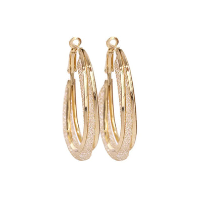The Monique Crystal Mesh Oval Hoop Earrings - A pair of stunning crystal-filled mesh hoop earrings in an elegant asymmetrical oval shape.