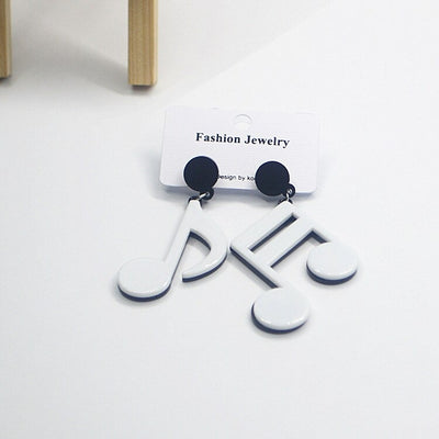 Retro Revival Notable Notes Earrings - Large asymmetrical acrylic earrings shaped like oversized musical notes, available in pink or white.