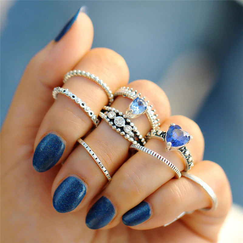 The Tefnut Ring Set - A collection of 8 matching finger and knuckle rings in a simple geometric style, with the occasional splash of vibrant blue.