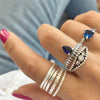 The Tefnut Ring Set - A collection of 8 matching finger and knuckle rings in a simple geometric style, with the occasional splash of vibrant blue.