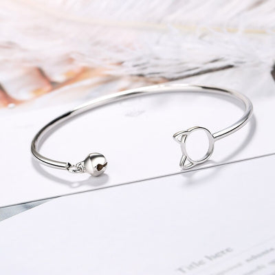 Tinklebell Silver Cat Bell Bangle - A delicate silver bracelet with a cat-shaped charm on one and and a small silver bell on the other.
