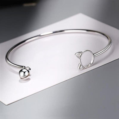 Tinklebell Silver Cat Bell Bangle - A delicate silver bracelet with a cat-shaped charm on one and and a small silver bell on the other.