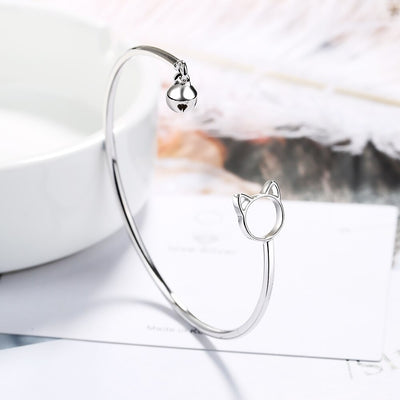 Tinklebell Silver Cat Bell Bangle - A delicate silver bracelet with a cat-shaped charm on one and and a small silver bell on the other.