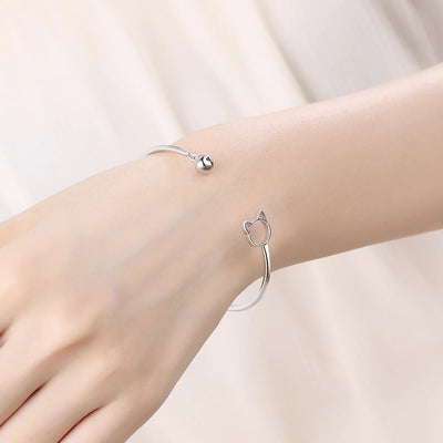 Tinklebell Silver Cat Bell Bangle - A delicate silver bracelet with a cat-shaped charm on one and and a small silver bell on the other.