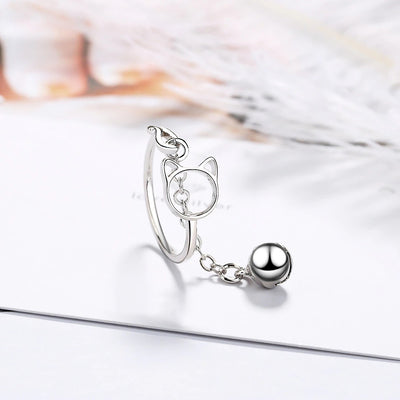 Tinklebell Silver Cat Bell Ring - An adjustable silver ring with a cat head charm on one side, and a small bell attached to a length of chain.