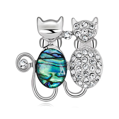 The Tropicana Makamae Brooch features a cute pair of kitty cats cuddled up together, one in paua and one encrusted with delicate gems.