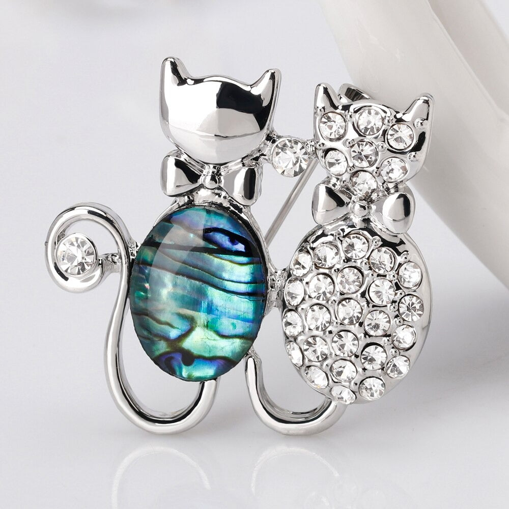 The Tropicana Makamae Brooch features a cute pair of kitty cats cuddled up together, one in paua and one encrusted with delicate gems.