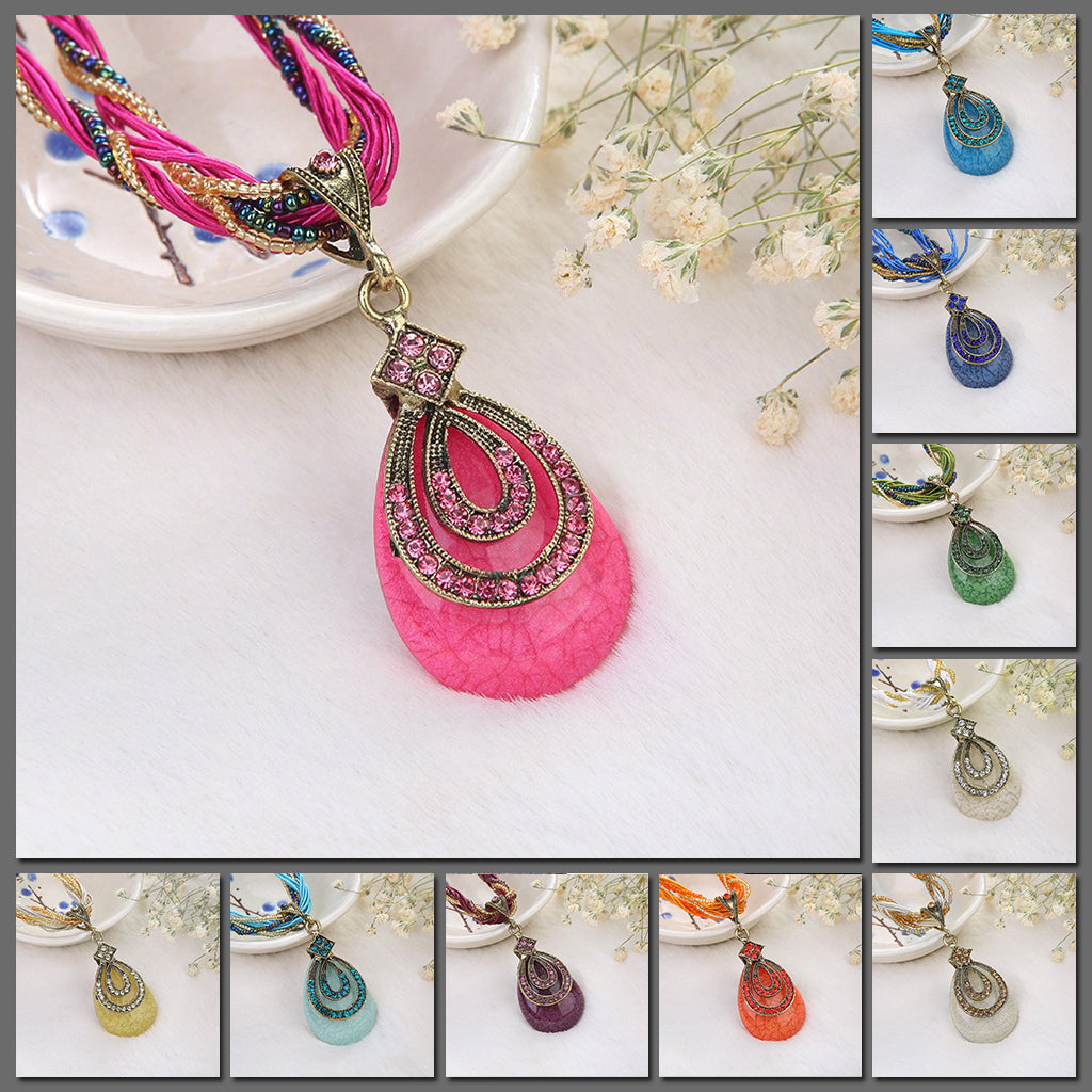 Upeka Beaded Statement Necklace - A chunky, teardrop-shaped resin pendant studded with matching crystals, strung from a leatherette strand and bead necklace.