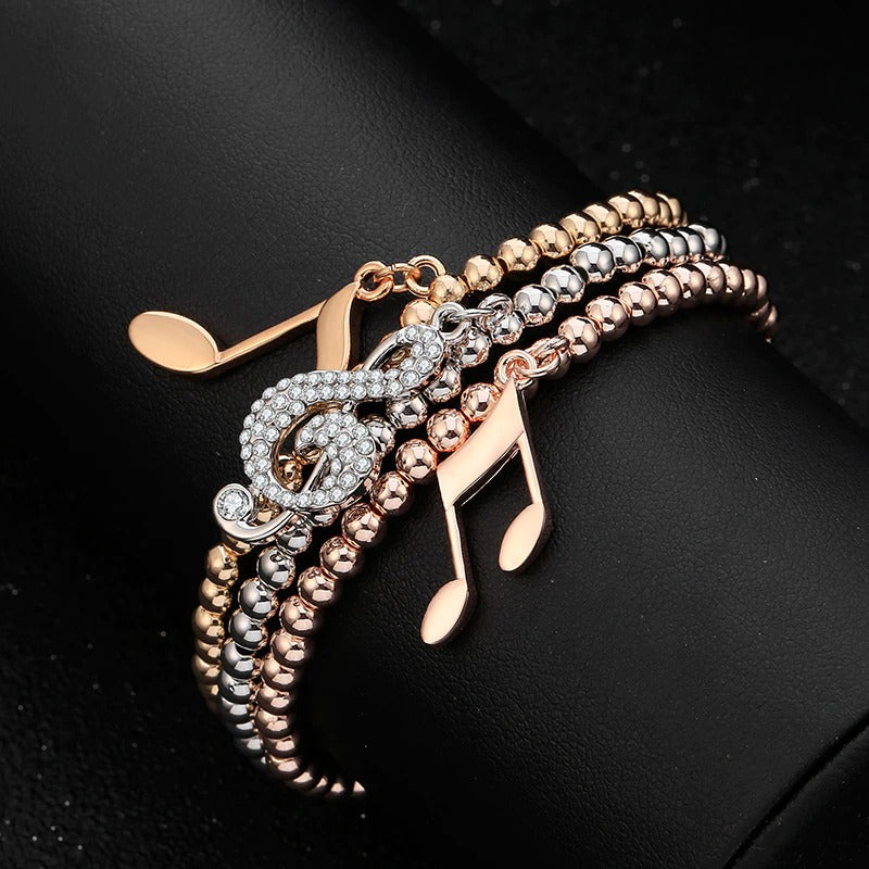 Whitney Stretch Bracelet Set - A set of simple beaded stretch bangles in beautiful gold, rose gold, or silver, with little charms that look like musical notes.