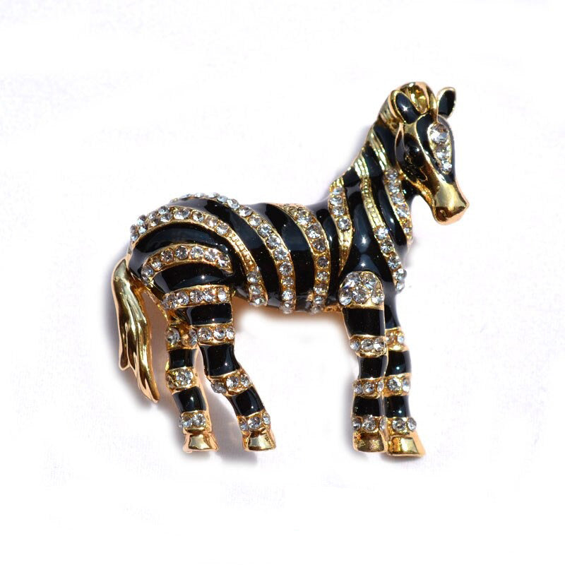 Zealous Zebra Brooch - A medium sized brooch shaped like a zebra standing still and looking forward, with a gold and black enamel background and studded with small crystals. 