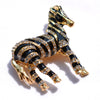 Zealous Zebra Brooch - A medium sized brooch shaped like a zebra standing still and looking forward, with a gold and black enamel background and studded with small crystals.